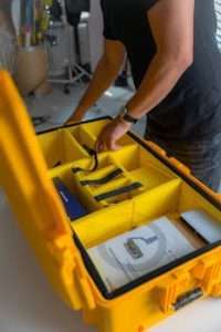 Arms of Man Packing Items in Yellow Box