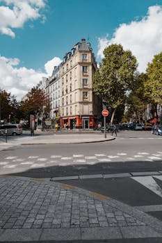 A vibrant street scene in Paris showcasing a classic European building under a bright blue sky.