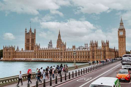 A vibrant view of Westminster Palace and Big Ben from Thames showing tourists and traffic.