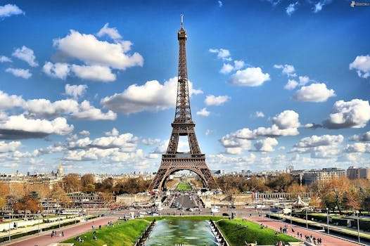 Stunning view of the Eiffel Tower with a backdrop of fluffy clouds and blue sky in Paris.