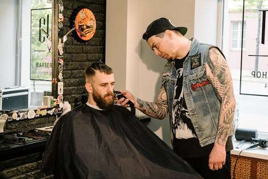 A stylish bearded man having a haircut in a modern barber shop.