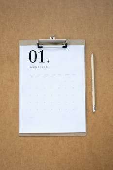 Flat lay of January 2021 calendar on brown clipboard with pencil, ideal for planning and organization.