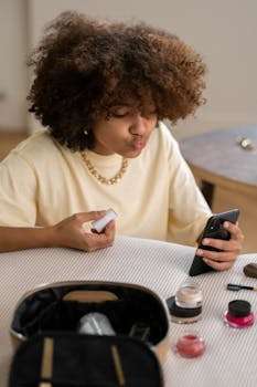 A young woman with afro hair vlogs about makeup products at home.